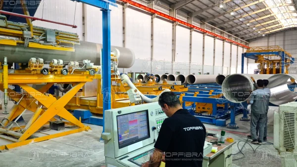GRP pipe production in progress using advanced EFW® Technology for high precision and efficiency Operator managing GRP pipe production using Effective Filament Winding® (EFW®) Technology